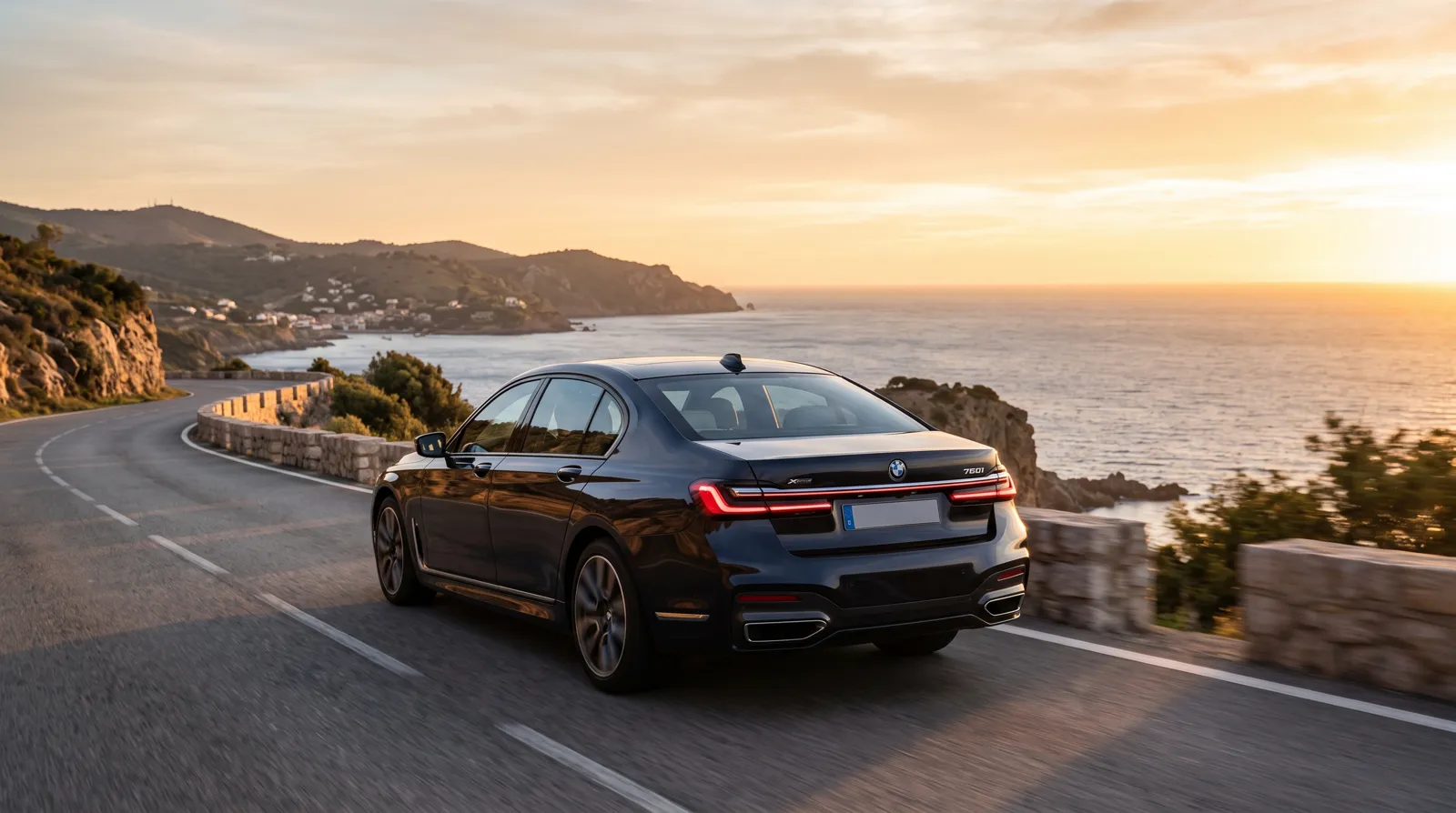 Donkere luxe sedan op een kustweg richting Zuid-Europa bij zonsondergang